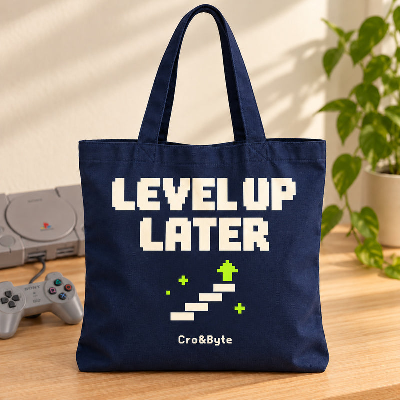 Level Up Later — Tote Bag — styled product photo with matching original PlayStation console and controller