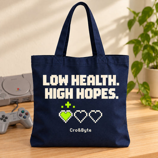 Low Health. High Hopes. — Tote Bag — styled product photo with matching original PlayStation console and controller