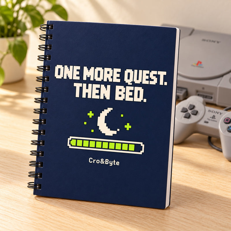 One More Quest. Then Bed. — Notebook — styled product photo with matching original PlayStation console and controller
